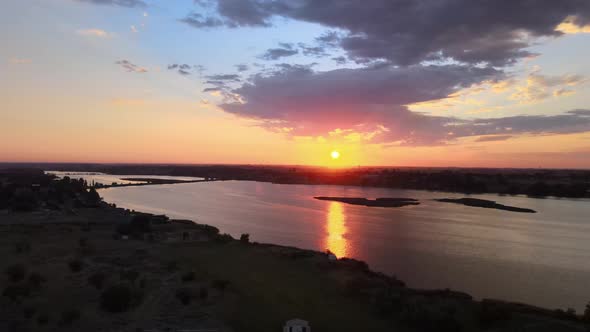 Golden sunrise reflection broken up by silhouetted island, Moses Lake, Washington, aerial