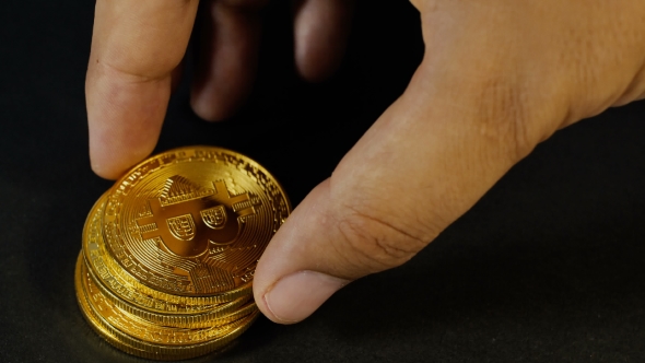 The Man's Hand Puts the Bitcoins in a Column. Hand Counting Gold Bitcoins. Crypto Currency Gold