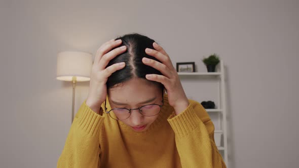 Depressed Asian woman putting her hands into her head feel hopeless about her job.