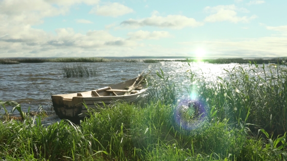 of Old Wooden Boat on the Lake in the Reeds, at Sunset.