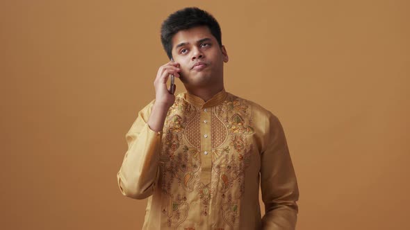 Confident Indian man in national cloth talking by phone