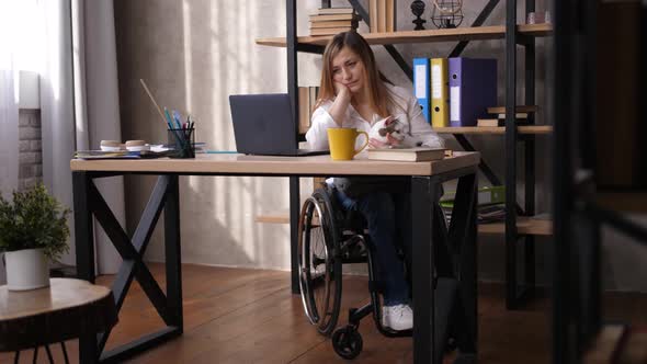 Upset Disabled Woman Looking at Screen of Laptop