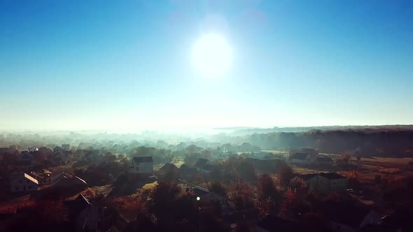 Aerial top view of the small houses at sunrise. Rural landscape of house roofs