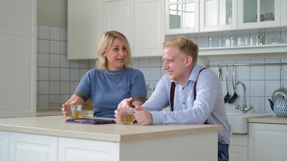 Mother with Adult Son Chatting While Drinking Tea