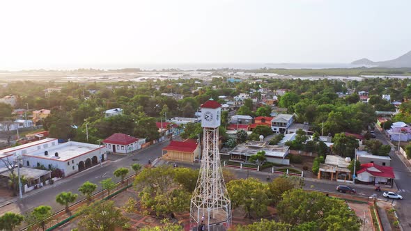 Drone flying close to clock tower with landscape of San Fernando de Montecristi in Dominican Republi