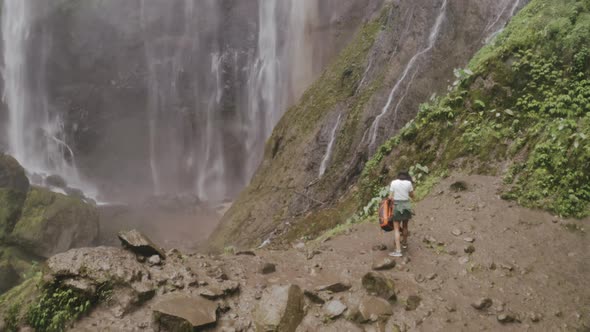 Traveler Stunned By Beautiful Waterfall Cascade in Jungle