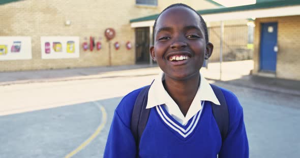 Portrait of a young schoolboy smiling in playground