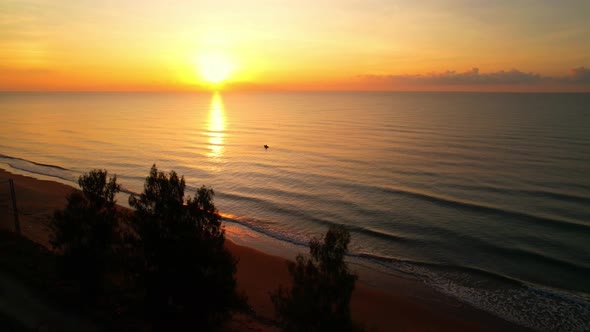 Aerial view from a drone, waves in the orange sea Sunset