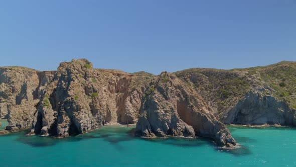 Aerial Pan of Cliffs and Rocks Cascading into the Aegean Sea in Milos Greece