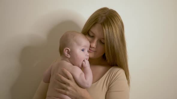 Mother Holds a Naked Child in Her Arms