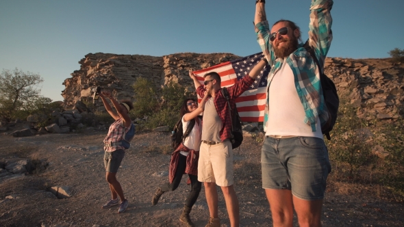 Excited Travelers Posing with Flag