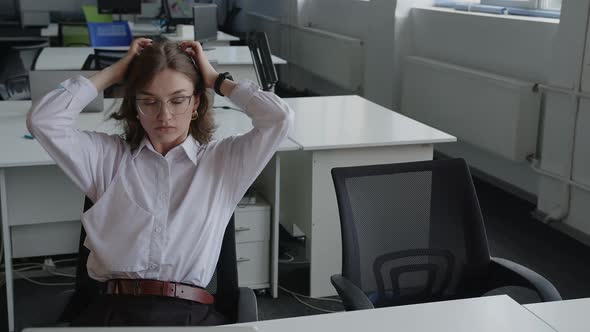 Tired Girl in an Office During Her Working Hours