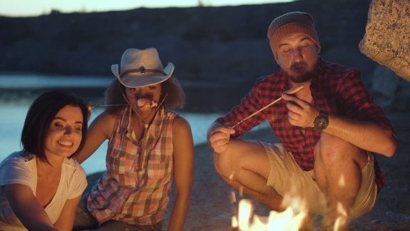 Friends in Night Eating Grilled Sausages