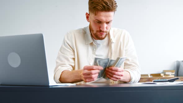 Concentrated male financial director with beard counts money banknotes