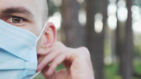 Young man puts on protective medical face mask, half face, close up. 