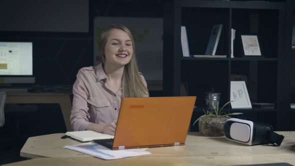 Young Woman Finishes Work in Office