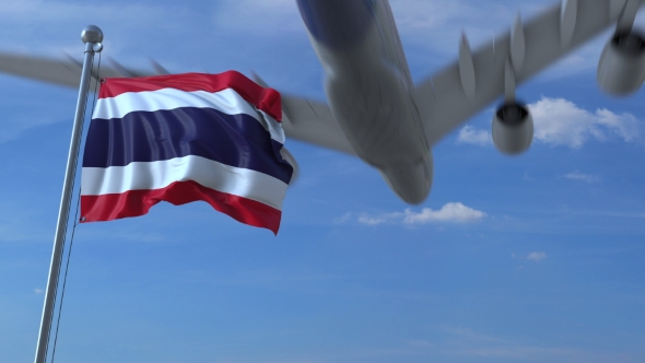 Commercial Airplane Landing Behind Waving Thai Flag