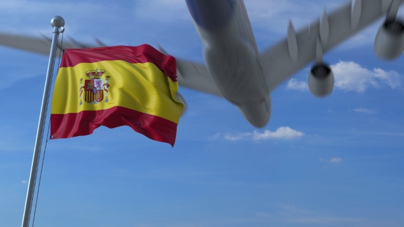 Commercial Airplane Landing Behind Waving Spanish Flag