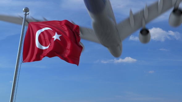 Commercial Airplane Landing Behind Waving Turkish Flag