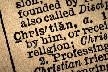 ebster’s Dictionary Macro Close-up of the word CHRISTIAN and its definition on old textured yellow paper.