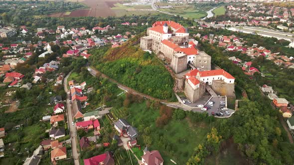Aerial View of Medieval Castle on Mountain in Small European City at Cloudy Autumn Day