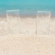 Two Glasses Filled with Juice on Sandy Beach, Against the Background of the Sea - VideoHive Item for Sale