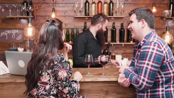 Hipster Bearded Bartender Pouring Wine To His Clients