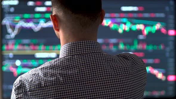 Millennial Man Trading Cryptocurrency Looking at Graphs and Indexes