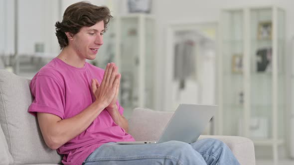 Cheerful Casual Young Man Doing Video Call on Laptop at Home 