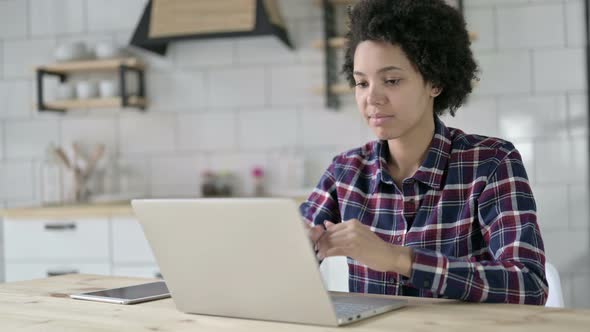 African American Woman Thinking and Working on Laptop