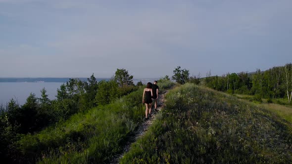 A Beautiful Couple of Young People Walking in the Mountainous Area. A Man and a Slender Girl