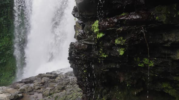 Rocky Stone From Which Streams of Water and Flow Against Background Power Waterfall