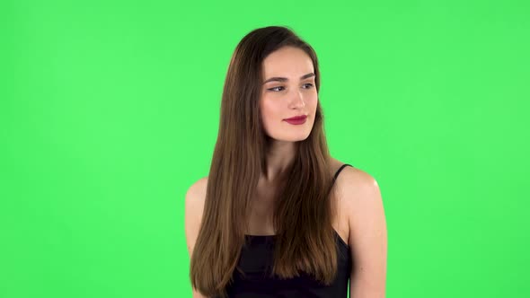 Young Woman Stands Waiting on Green Screen