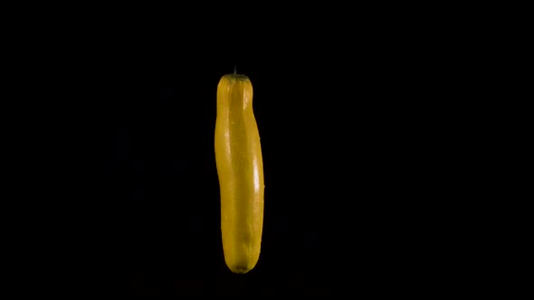 Yellow zucchini on black background seems to dance. Room for text. Part of series.