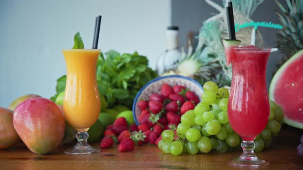 Left to right panning shot of fresh fruits and freshly made fruit juice and smoothies