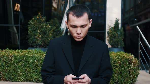 Serious Modern Startup Businessmen Receiving Bad News on His Mobile Phone While Texting Outside an