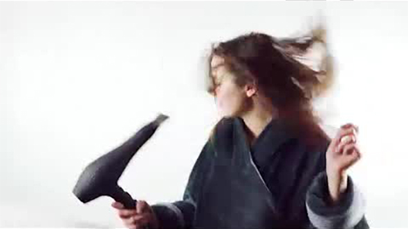 Footage of Beautiful Young Woman Singing at Hair Dryer Isolated on the White Background