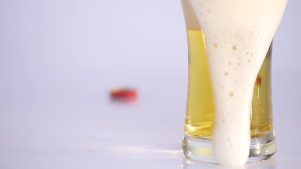 Glass of Beer Emptying on White Background.