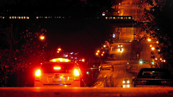 Cars On Hill In City With Subway Passing At Night