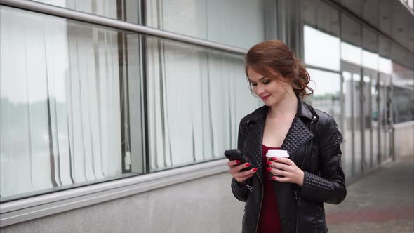 Girl with Mobile Browsing Social Media and Having Coffee on the Way