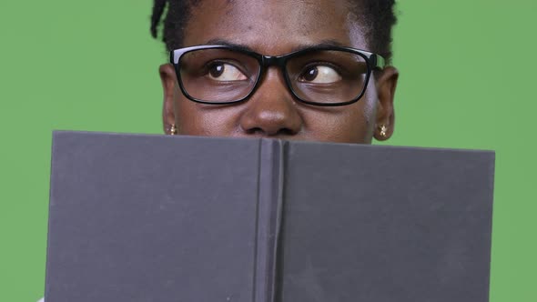 Young Beautiful African Businesswoman Covering Face with Book