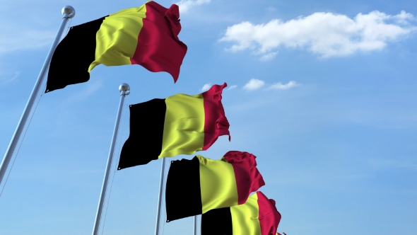 Row of Waving Flags of Belgium Agaist Blue Sky alt