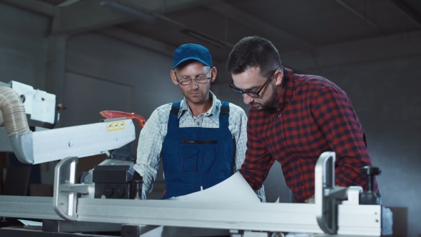 Designer and Carpenter Discussing Drawings