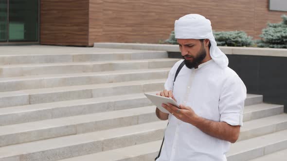 Muslim Man Using Tablet Computer Outdoors