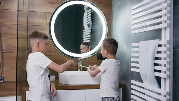 Brothers which Standing in Front of Bathroom Mirror and Cleaning Teeth, Giving High Five Each Other