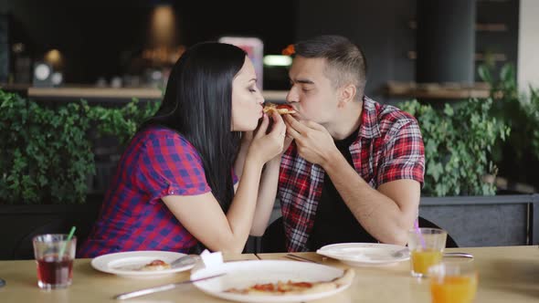 Romantic Couple are Eating One Slice of Pizza Together