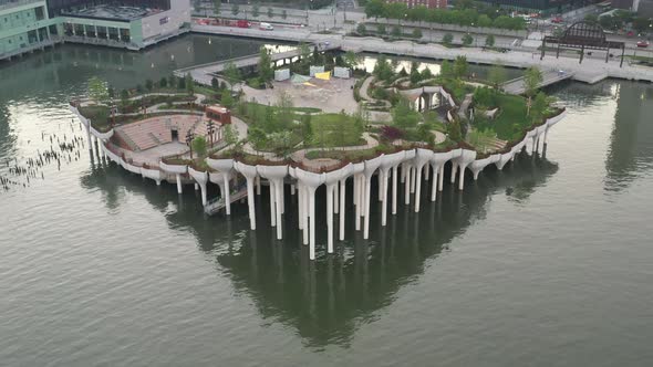 An aerial view of Manhattan's Little Island, a public green space on a sunny morning. The camera dol