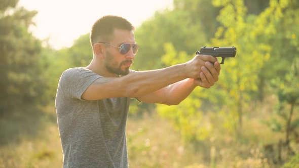 Young Man Is Shooting From a Gun