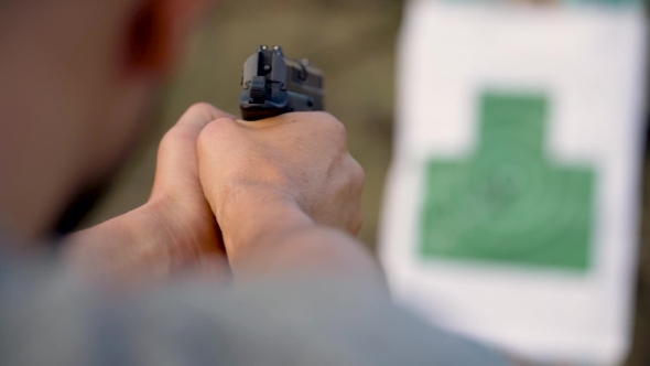 Young Man Is Shooting From a Gun at the Target