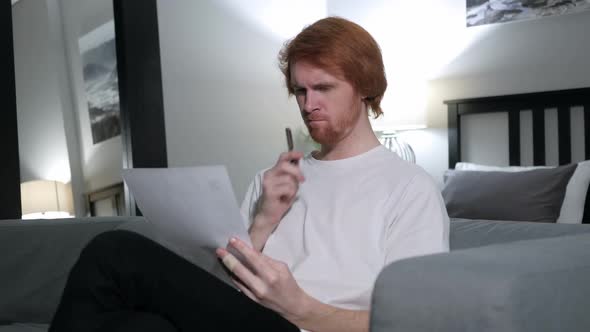 Penisve Redhead Man Reading Letter Sitting on Sofa